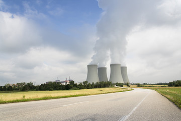 Cooling towers with steam vapour at nuclear power station on sunny day