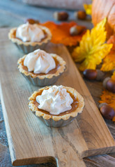 Miniature pumpkin pies displayed on a wood table