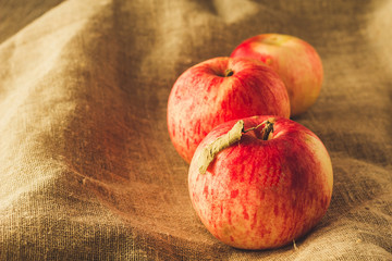 Tree red apples on linen cloth filtered