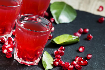 Fresh pomegranate juice on a black background, selective focus