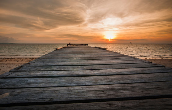 orange sunset with jetty as foreground
