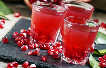 Fresh pomegranate juice on a black background, selective focus