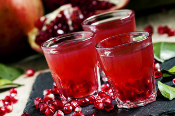 Fresh pomegranate juice on a black background, selective focus