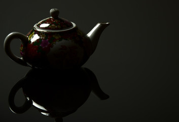 Chinese jug with a mirror image on a black background