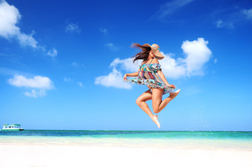 Carefree young woman is jumping into the sky