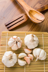 garlic on wicker bamboo on wooden background