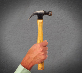 Hand of handyman with a hammer.
