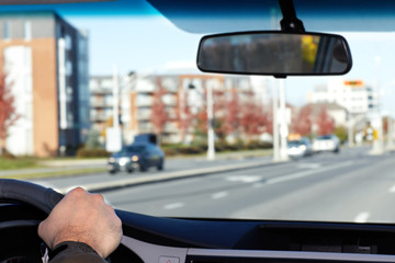 Hand of man driving on a highway.