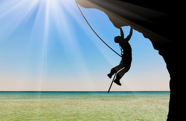 Silhouette climber climbing a mountain