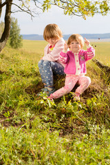 Fototapeta premium The sisters sitting on the grass