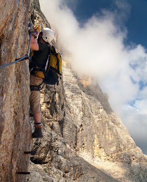 climber on via ferrata or klettersteig - dolomites