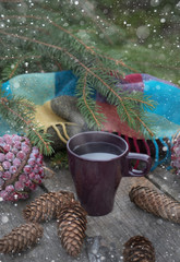 Сup of hot tea on a rustic wooden table. Still life of cones, twine, patskthread, fir branches....