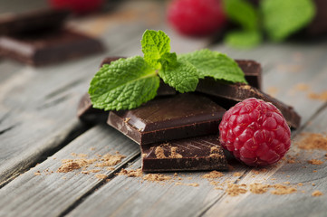 Dark chocolate with mint and raspberry on the vintage table