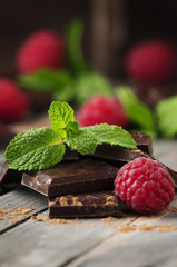 Dark chocolate with mint and raspberry on the vintage table