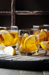 Cold whiskey with ice and lemon on the vintage table
