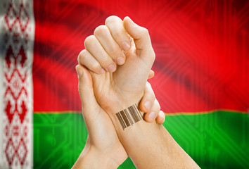 Barcode ID number on wrist and national flag on background - Belarus
