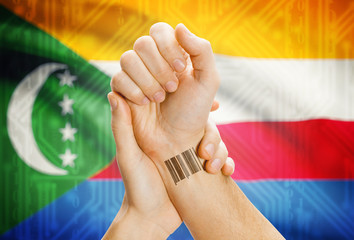 Barcode ID number on wrist and national flag on background - Comoros