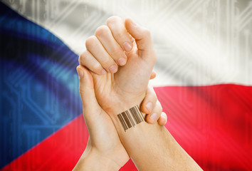 Barcode ID number on wrist and national flag on background - Czech