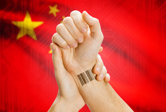 Barcode ID number on wrist and national flag on background - China