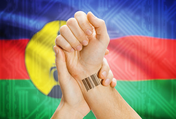 Barcode ID number on wrist and national flag on background - New Caledonia