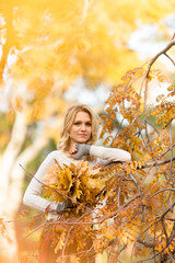 Blond woman with bouquet from maple leaves