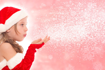 blondes Mädchen im Weihnachstmann Kostüm pustet