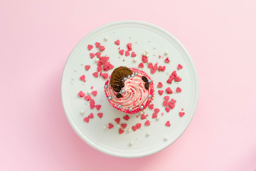 Pink strawberry cupcake with pink background, top view