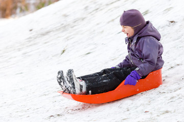 Girl playing with sleigh in winter snow
