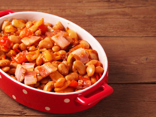 Beans and bacon prepared for baking in oven