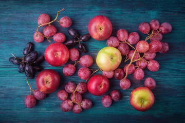 Top view of fresh grapes and apples on wooden background