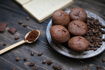 coffee chocolate muffins on a plate on a table with a book and a spoon