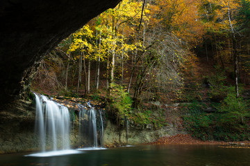Fototapeta na wymiar cascade et sous bois aux couleurs d'automne
