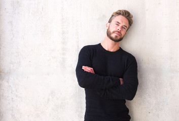 Male fashion model with beard posing with arms crossed - obrazy, fototapety, plakaty