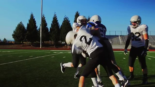 A football player gets tackled during a scrimmage game
