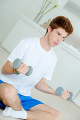 Fototapeta na wymiar Teenager sat doing weights