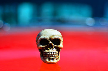 Skeleton on a red sports muscle car