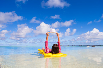 Young happy woman relaxing on air mattress during beach vacation