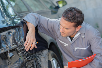 Mechanic taking notes of a car's faults