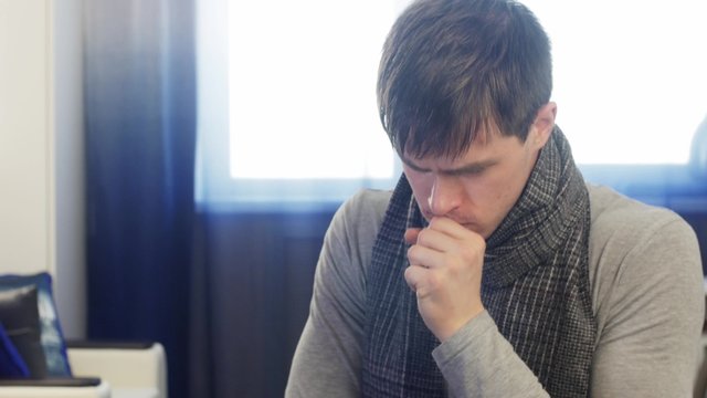 Sick man coughing really hard. Static shot