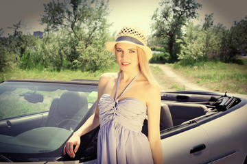 Pretty girl standing near cabriolet, outdoors