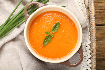 Carrot cream-soup with vegetables on table close up