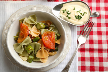 Roasted asparagus and tasty pasta with vegetables in bowl on wooden table background