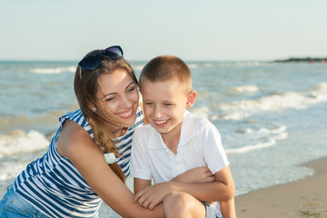 Fototapeta na wymiar Mother and her son having fun on the beach