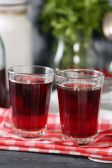 Sweet homemade cherry juice on table, on color background