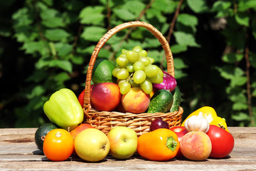 Heap of fresh fruits and vegetables in basket on table outdoors