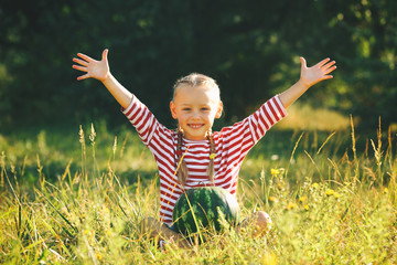 Small girl with watermelon on lawn