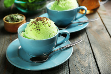 Homemade Green tea ice-cream in cup, on wooden background
