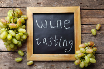 old chalk scripted frame with grape on wooden background