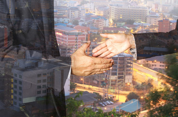 Double exposure of handshake and city