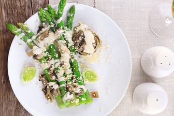 Appetizing dish with asparagus and mushrooms on served table in the restaurant